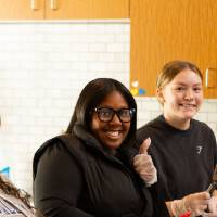 Students cooking food & holding a spatula